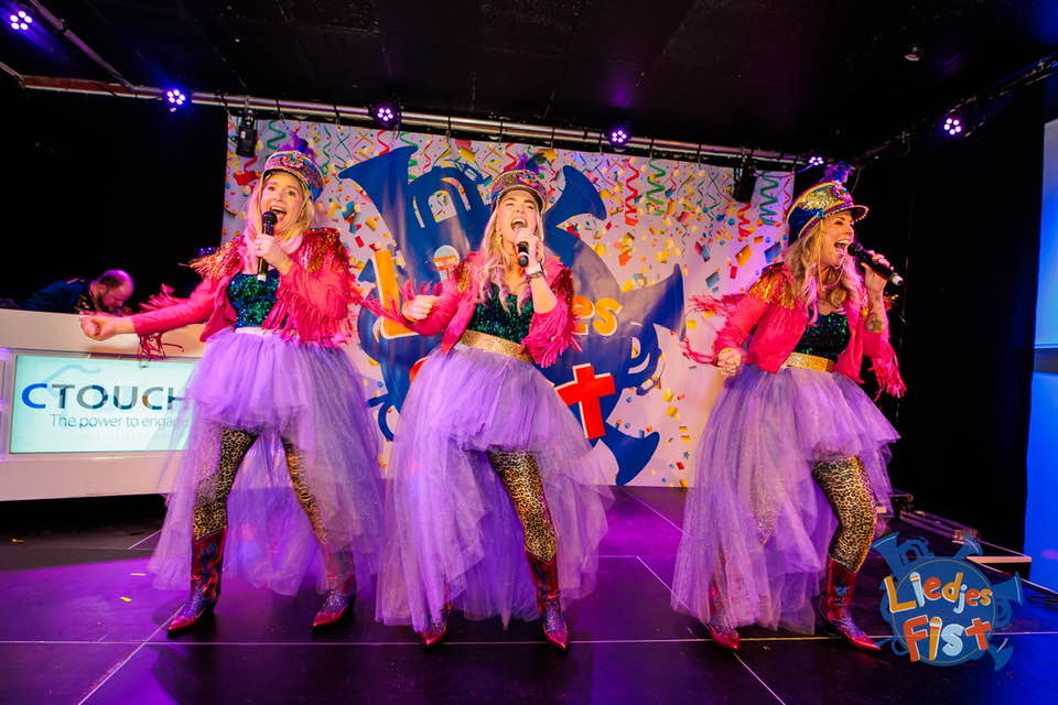 Zangeressen met glitterhoeden op het podium van het Liedjesfist